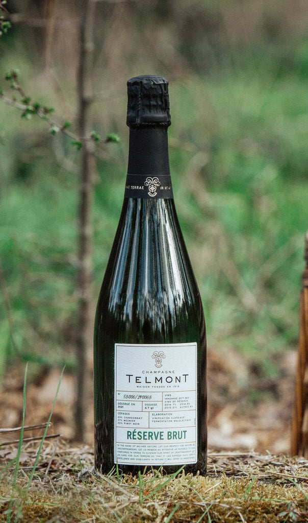A bottle of champagne Reserve Brut on a grassy background